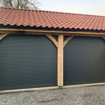 Twin anthracite roller shutter garage doors fitted under an oak-framed carport roof